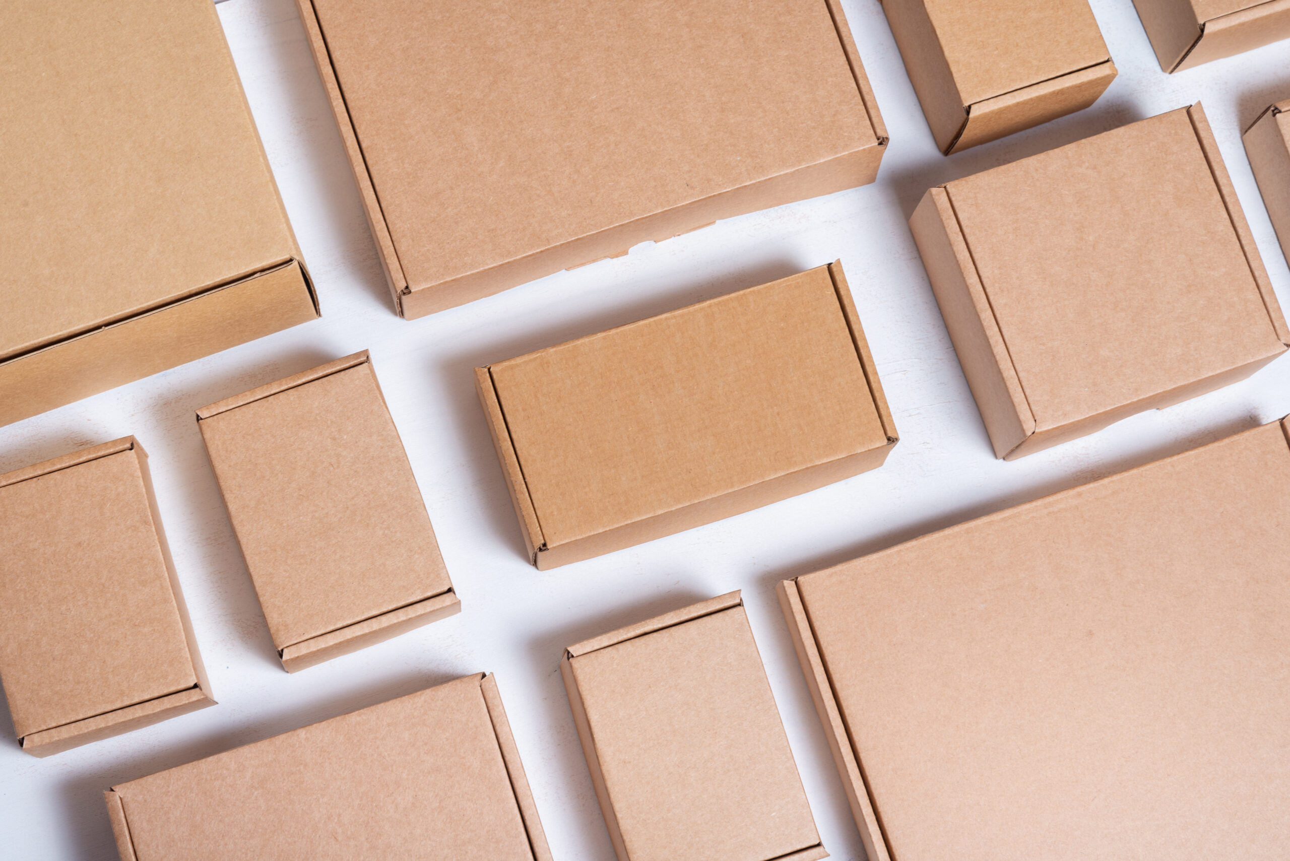gran-cantidad-cajas-carton-marron-sobre-fondo-blanco-madera